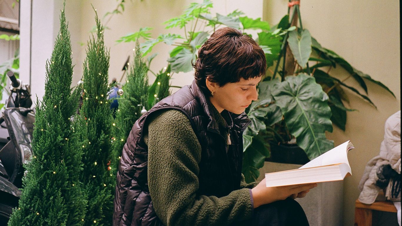 A woman sitting on a bench reading a book