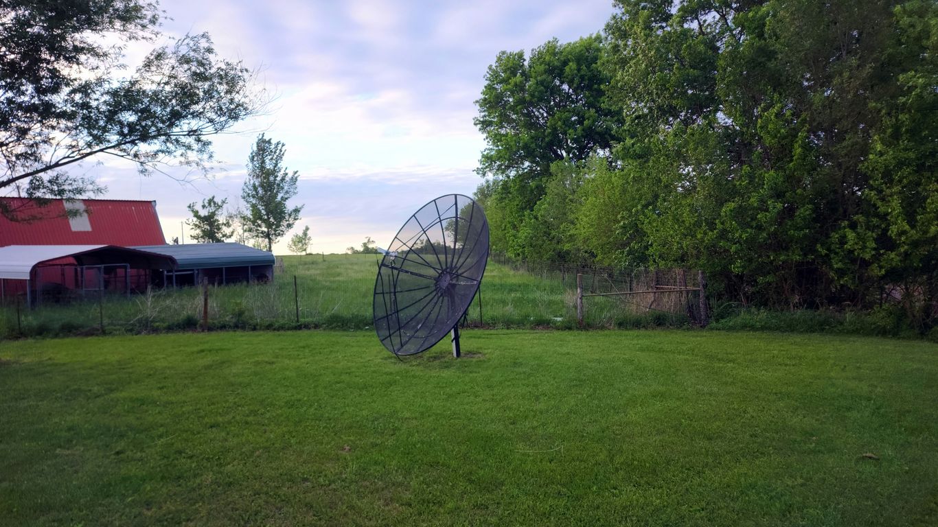 a large metal object sitting on top of a lush green field