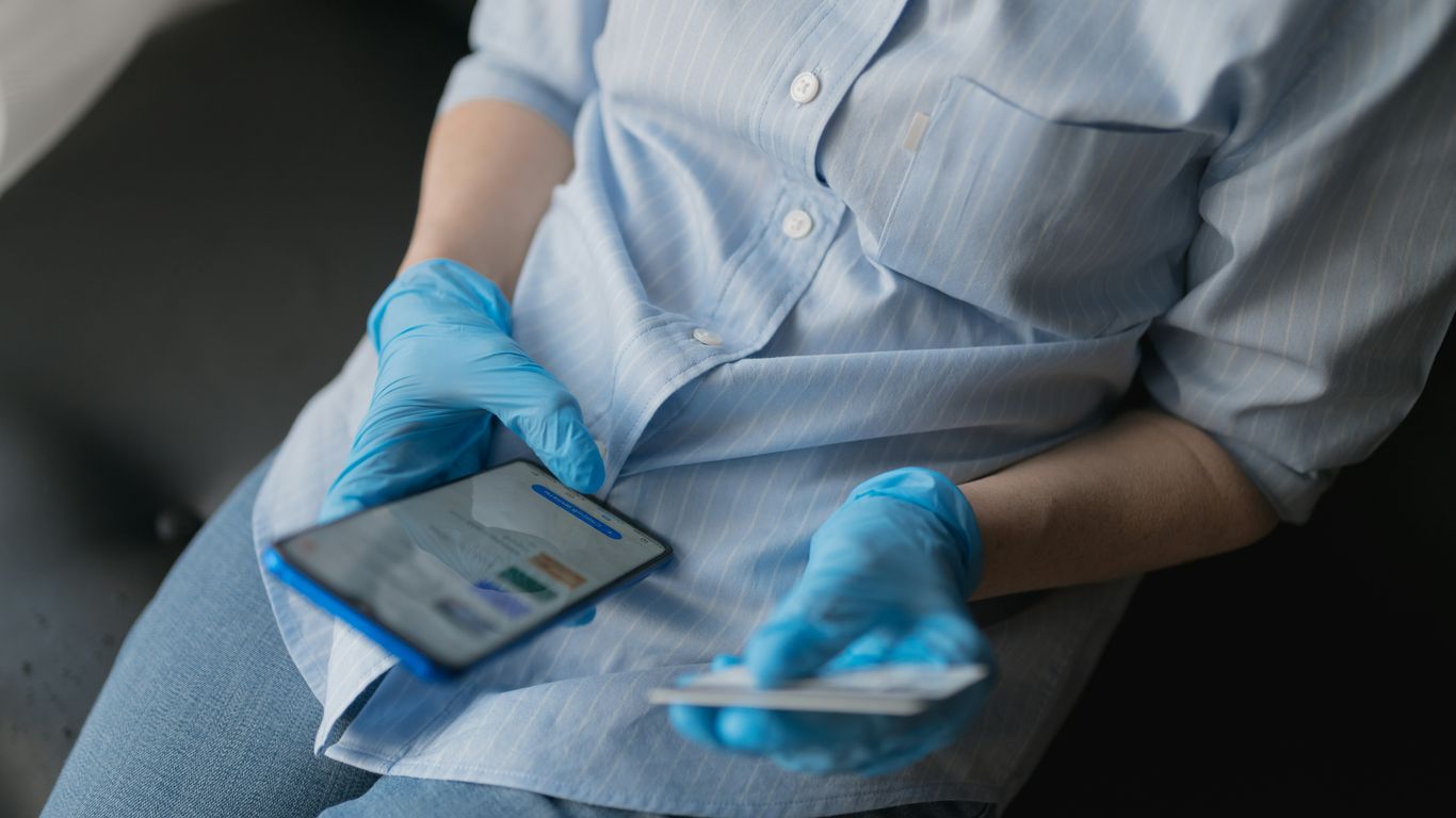 person in blue button up shirt and blue denim jeans sitting on gray couch
