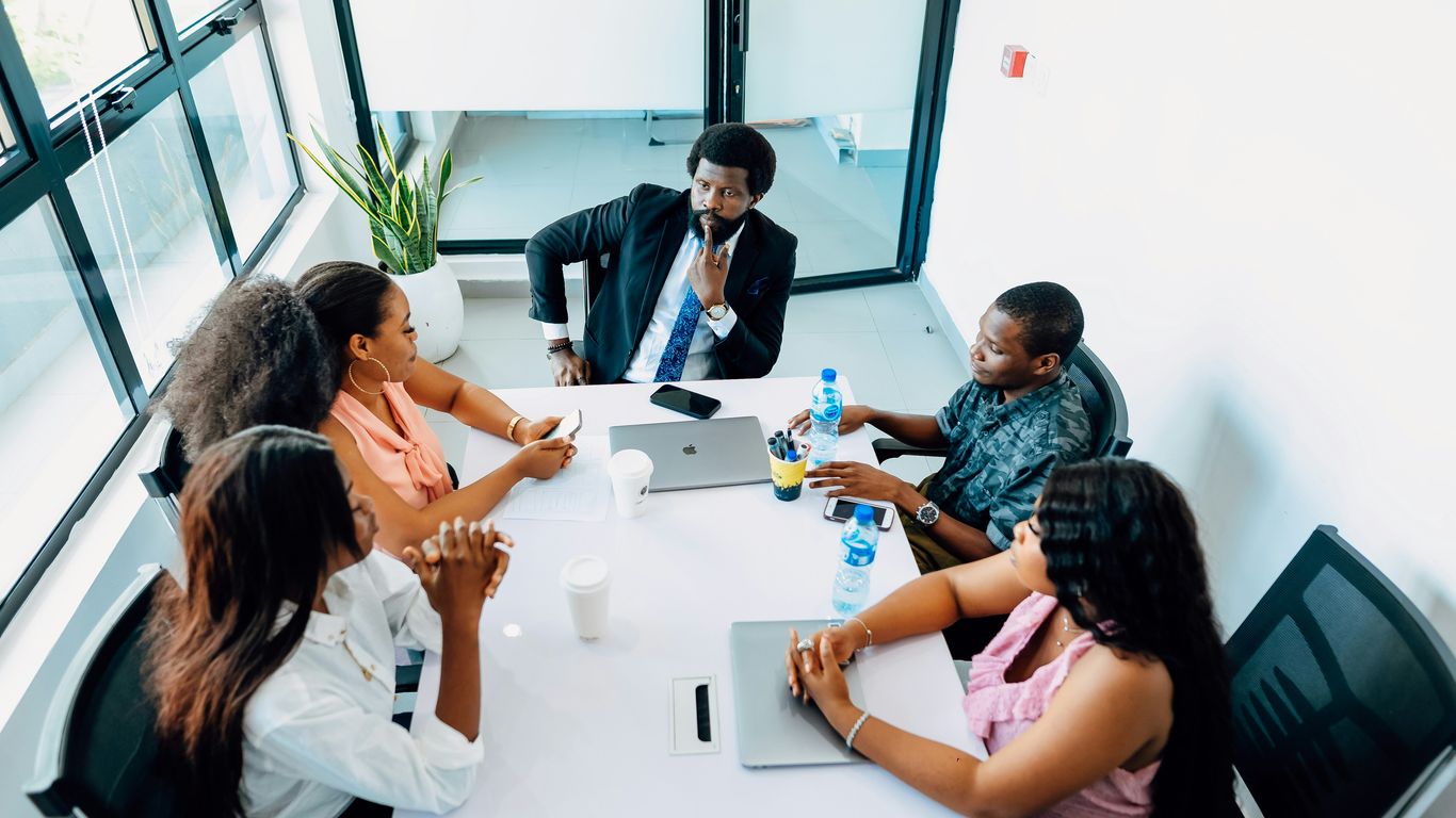 A group of people sitting around a white table