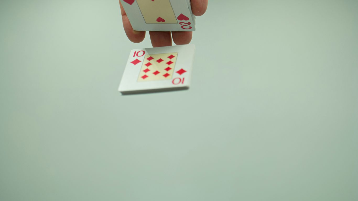 a person holding a playing card in their hand