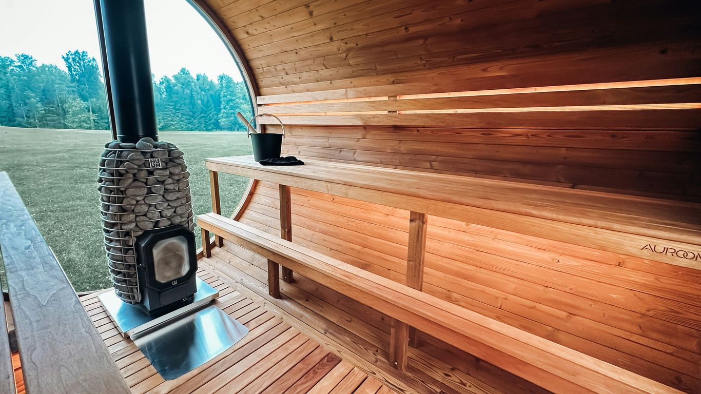 Wooden sauna interior with wood-burning stove and benches.