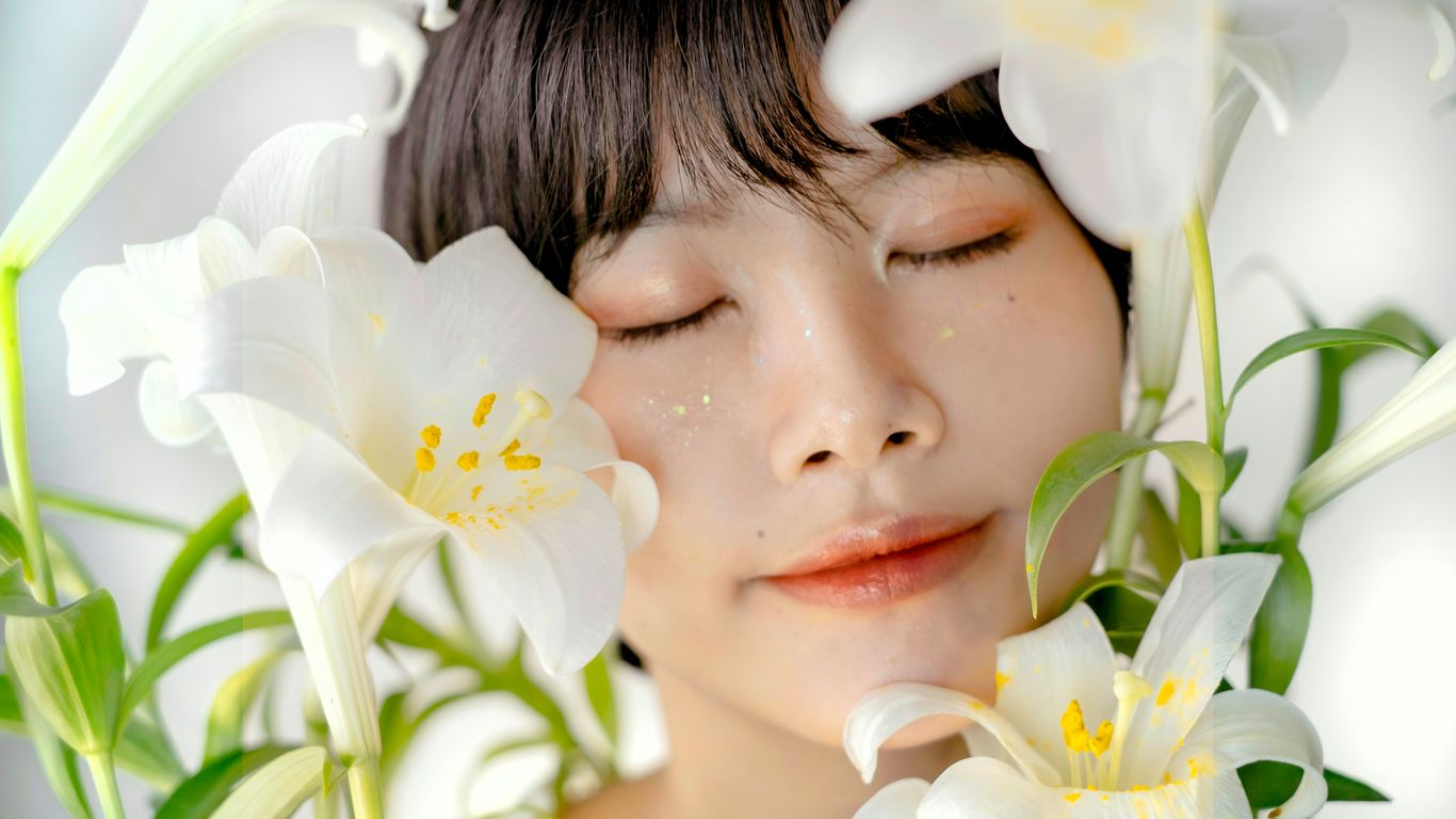 a woman with her eyes closed and flowers in her hair