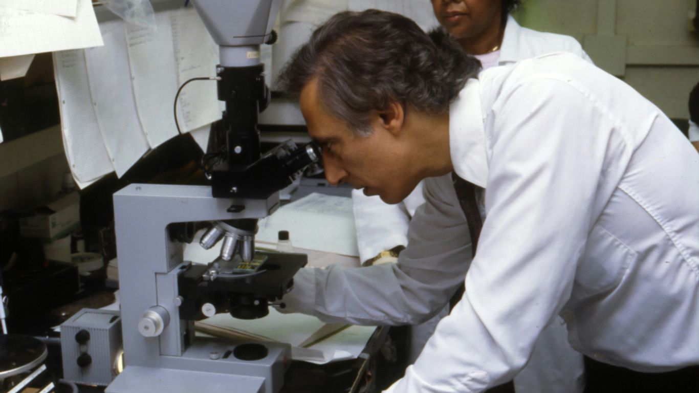 man using microscope