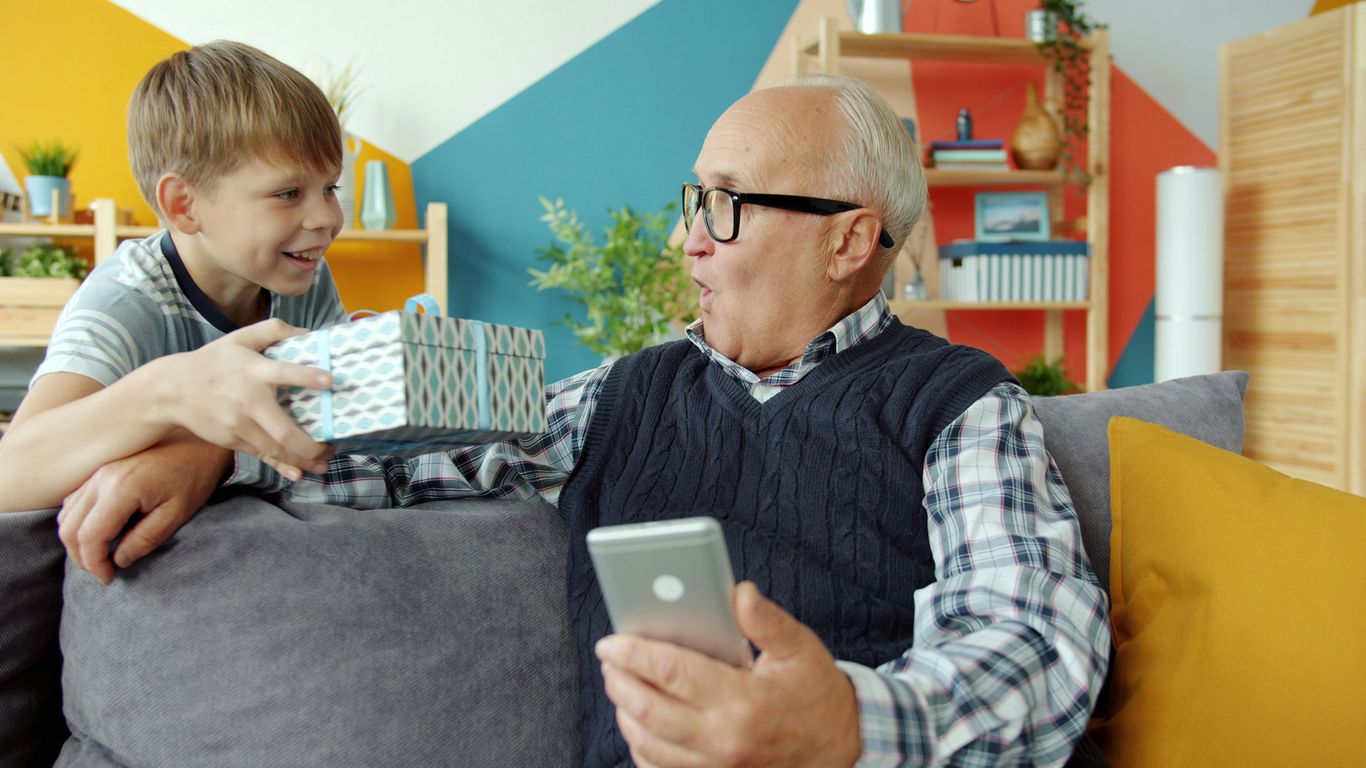 Boy gives surprised grandfather a gift