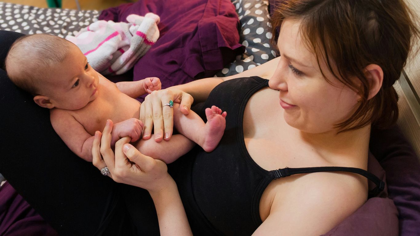 lying woman holding baby