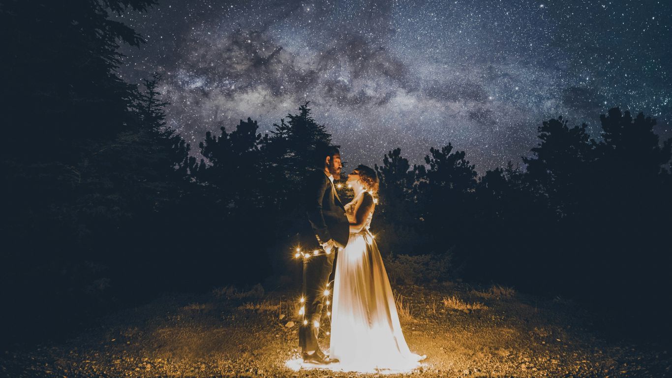 man and woman standing on floor surrounded by yellow string lights
