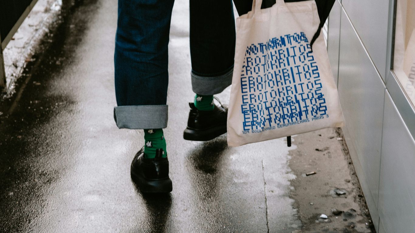 a person walking down a sidewalk carrying a bag
