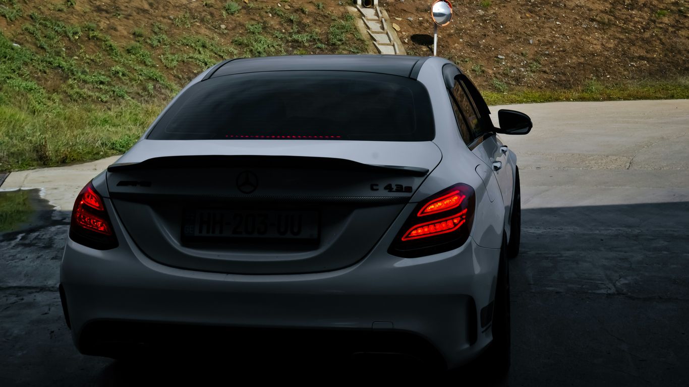 a car parked in a parking lot next to a hill