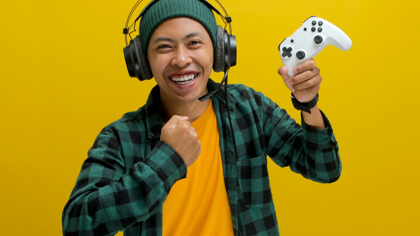 A man wearing headphones and holding a video game controller