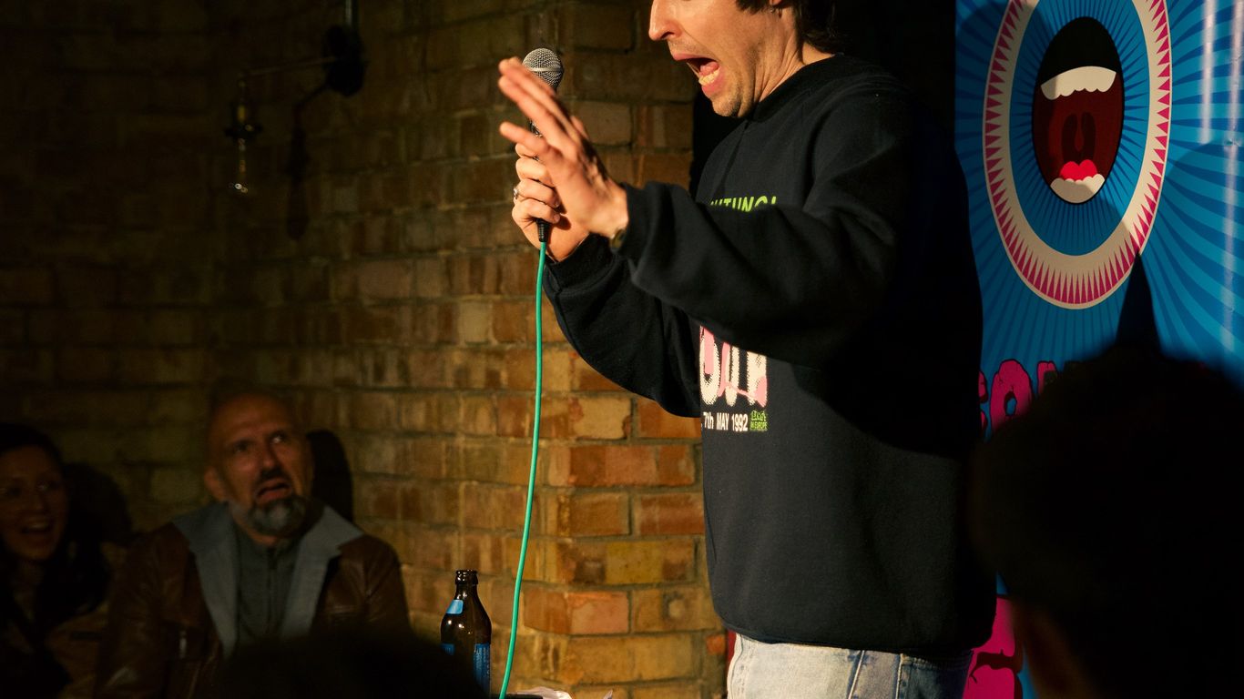 A comedian performs on stage in front of an audience.
