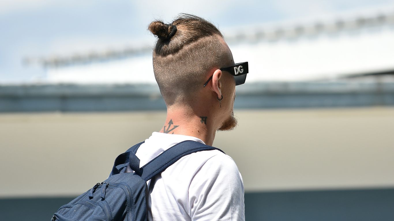 a man with a mohawk undercut wearing a back pack