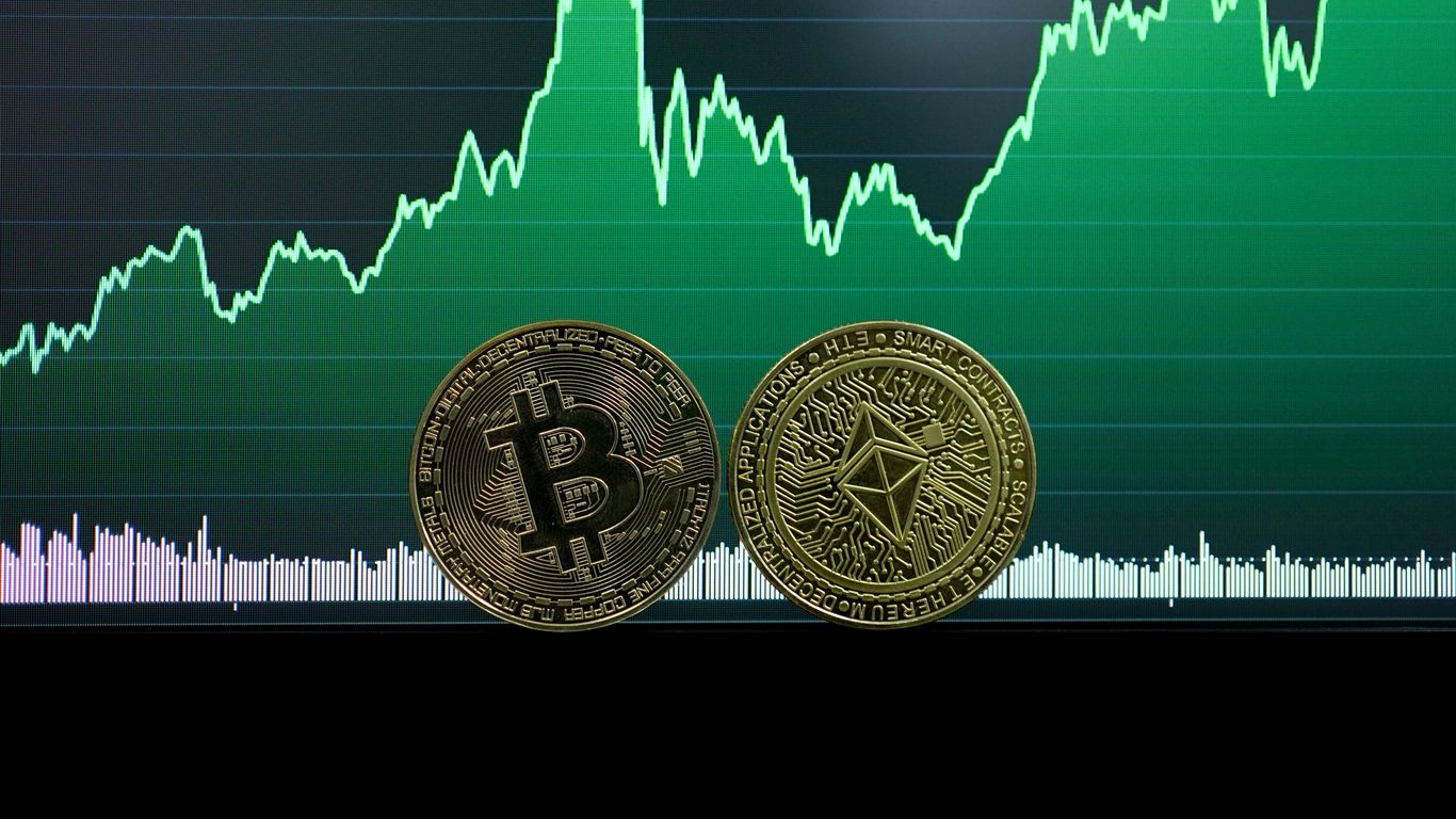 Two cryptocurrency coins in front of a fluctuating graph.