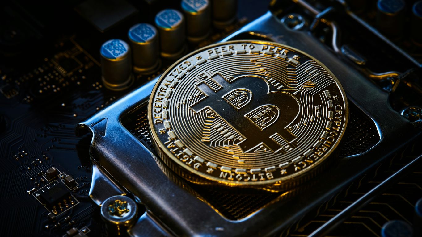A close-up of a shiny Bitcoin on a circuit board.