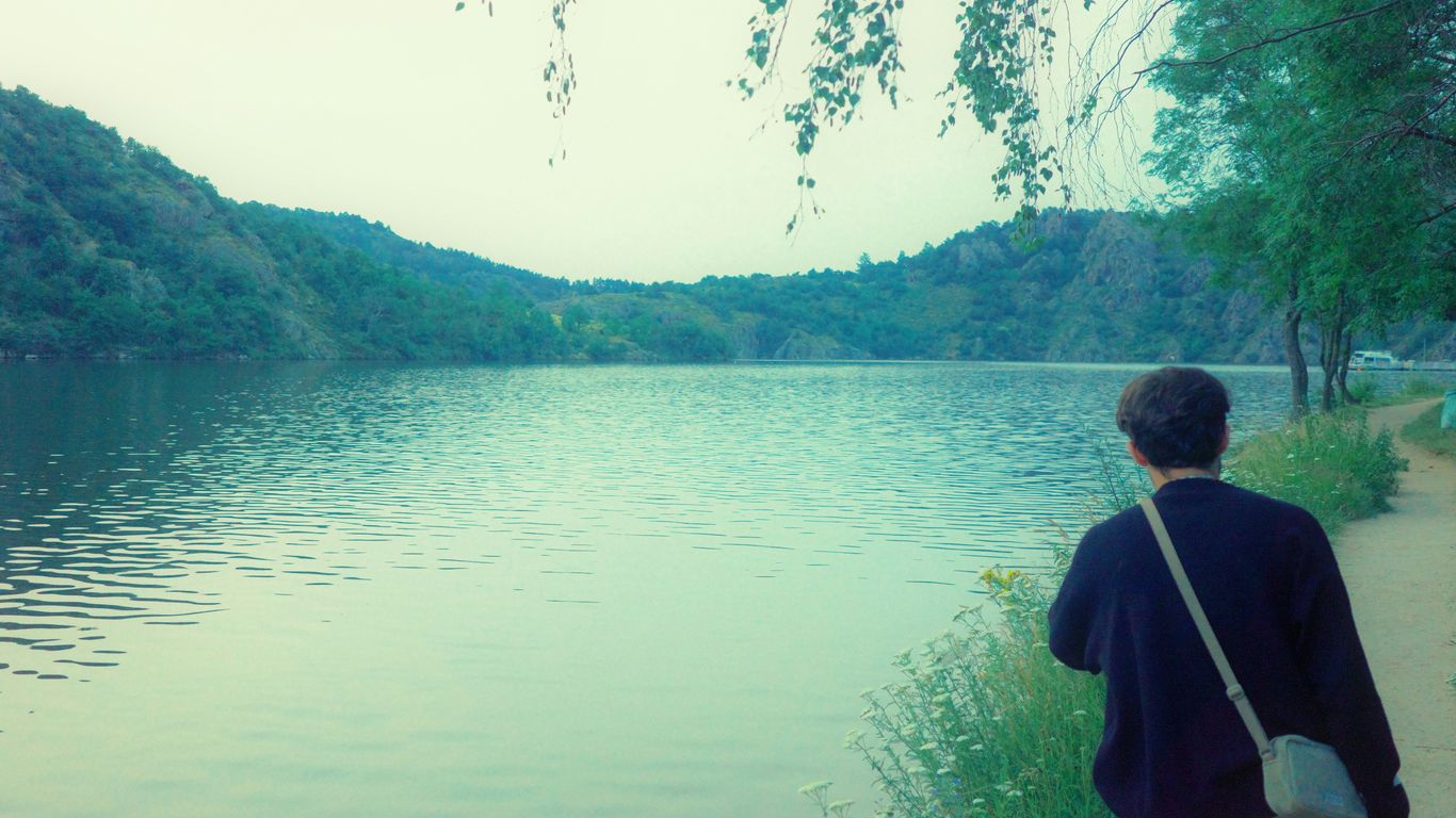 a person standing on a path near a body of water