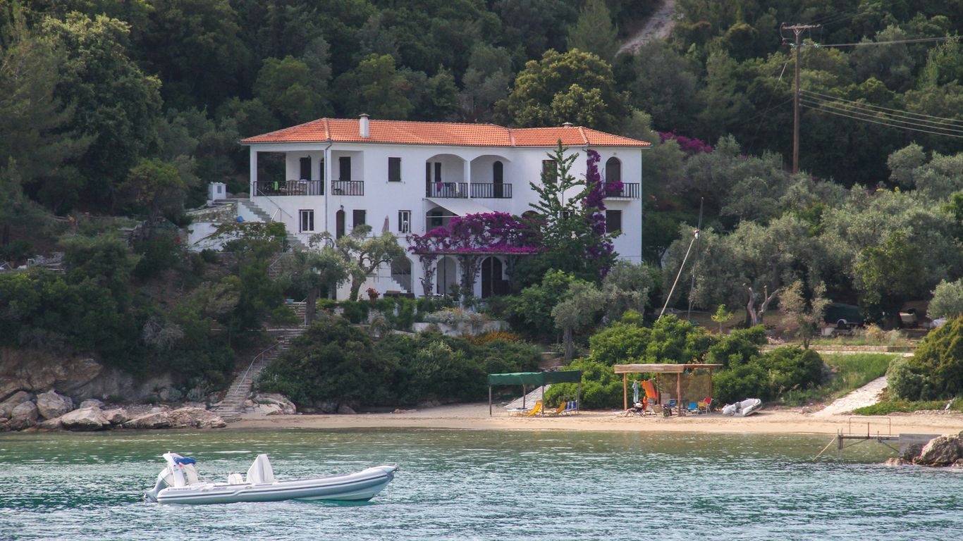 a boat is in the water in front of a house