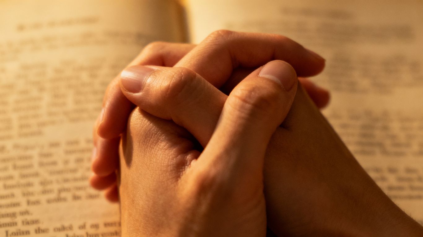 Intertwined hands amidst classic literature.