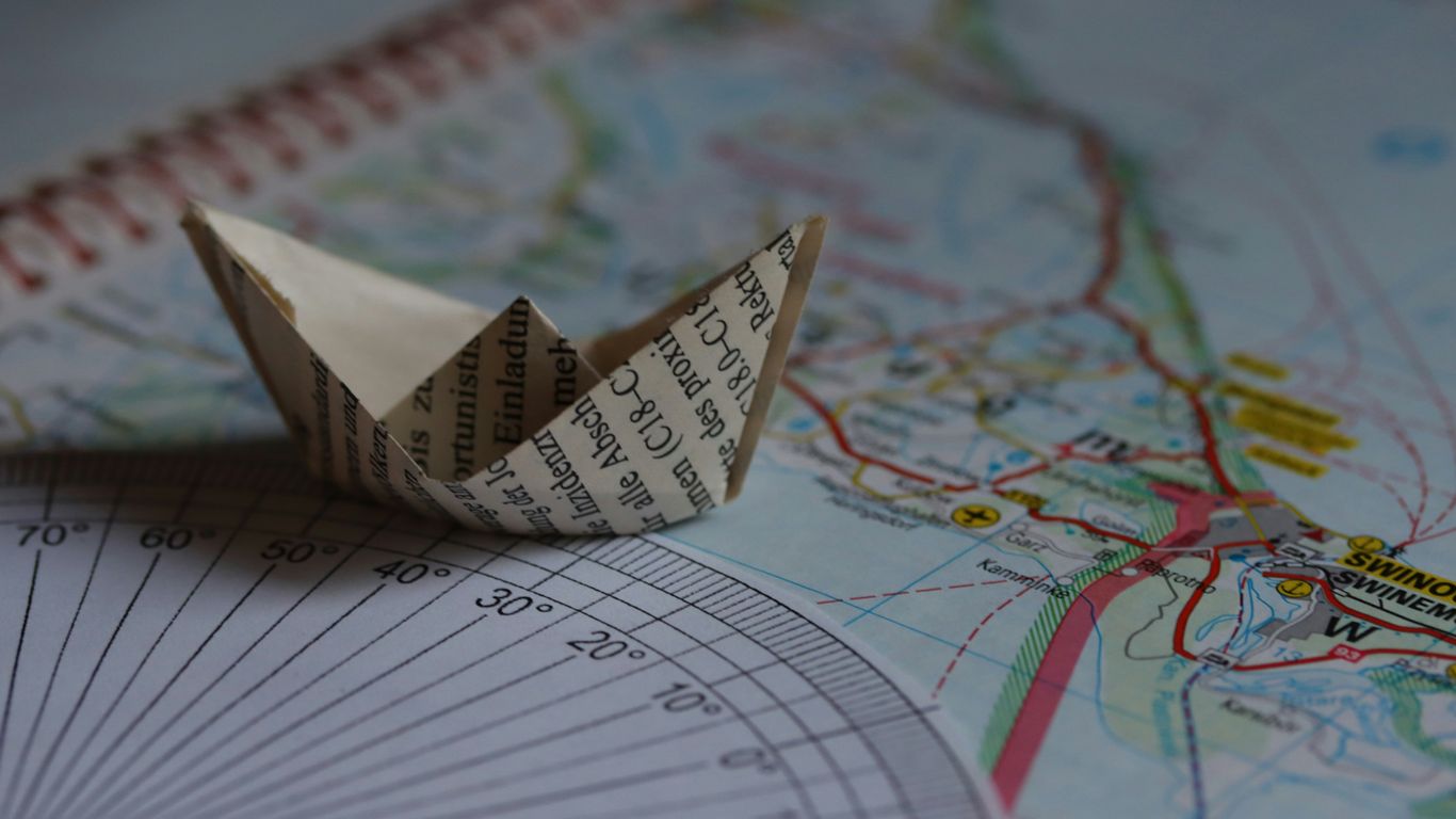 A paper boat sits on a map.