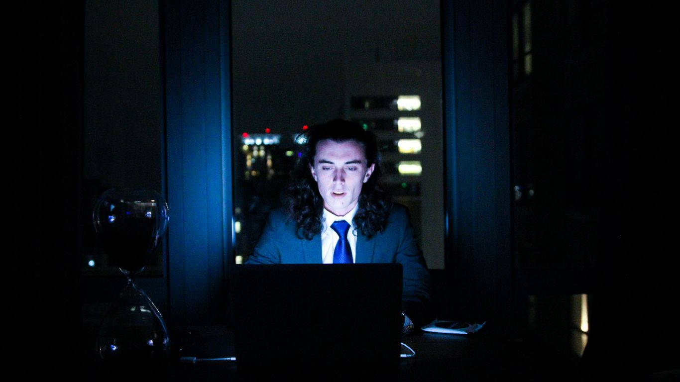 man using computer in dark room