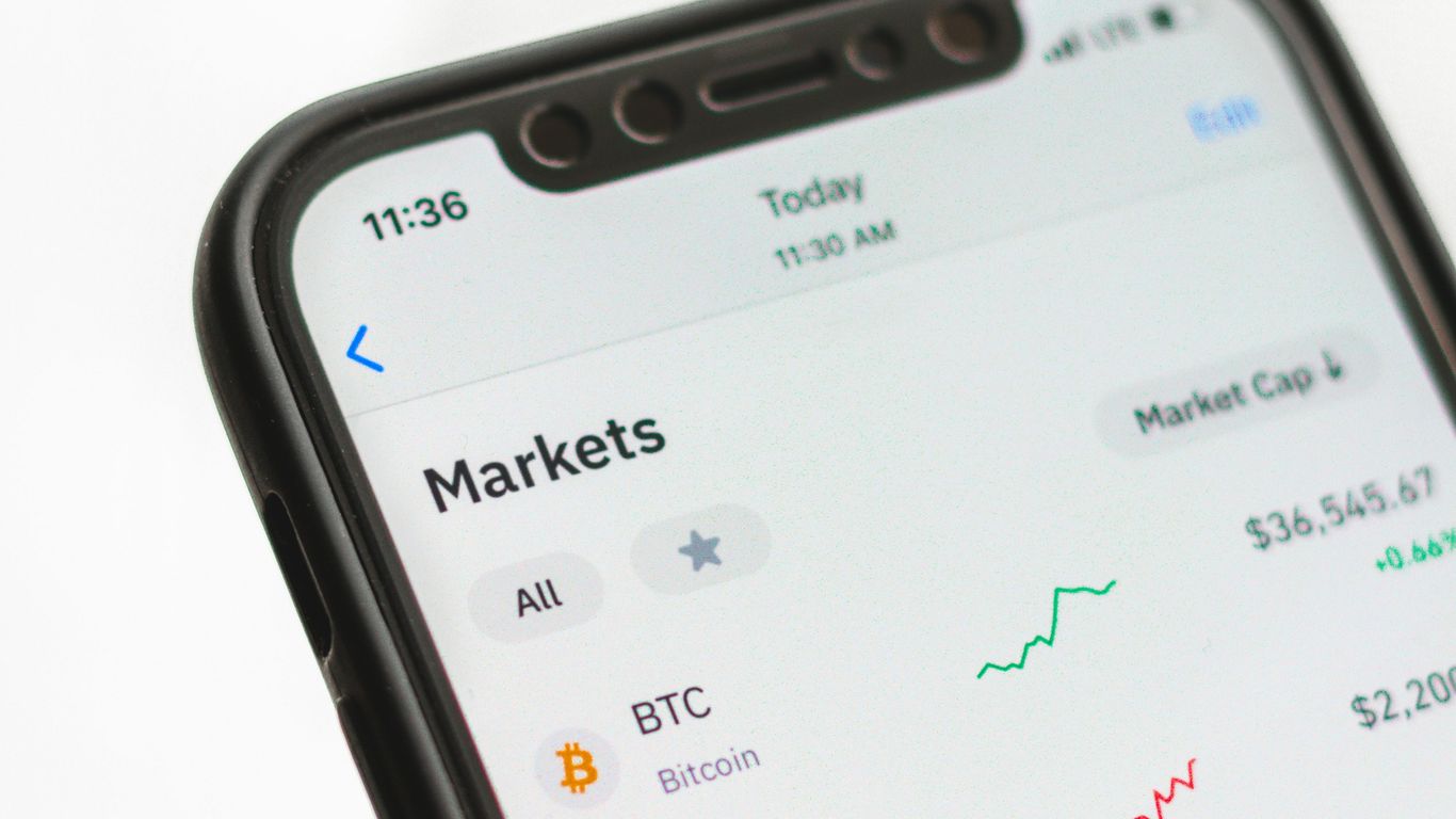 Smartphone displaying cryptocurrency market data and performance trends.