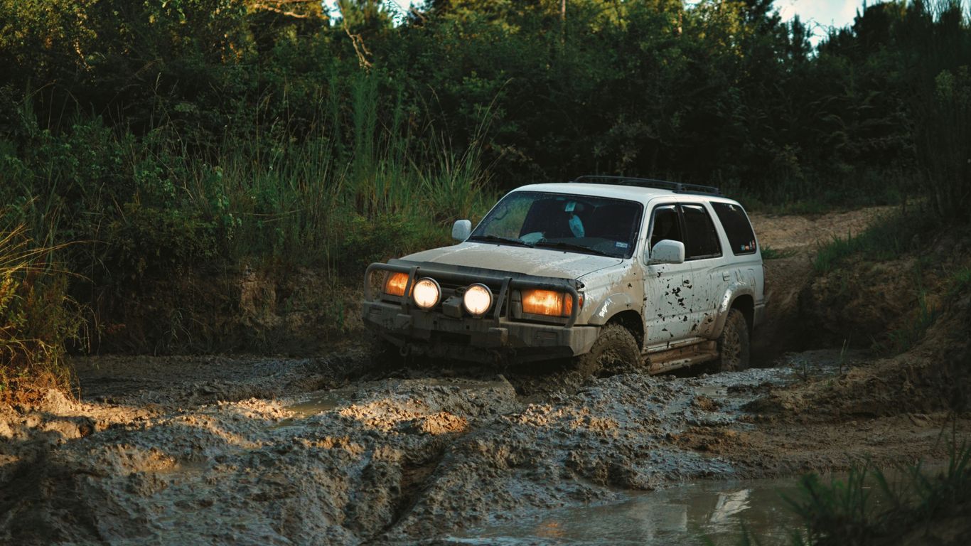 white suv on brown dirt road