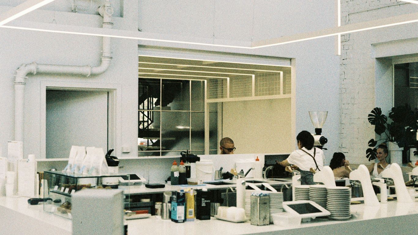A group of people standing around a kitchen