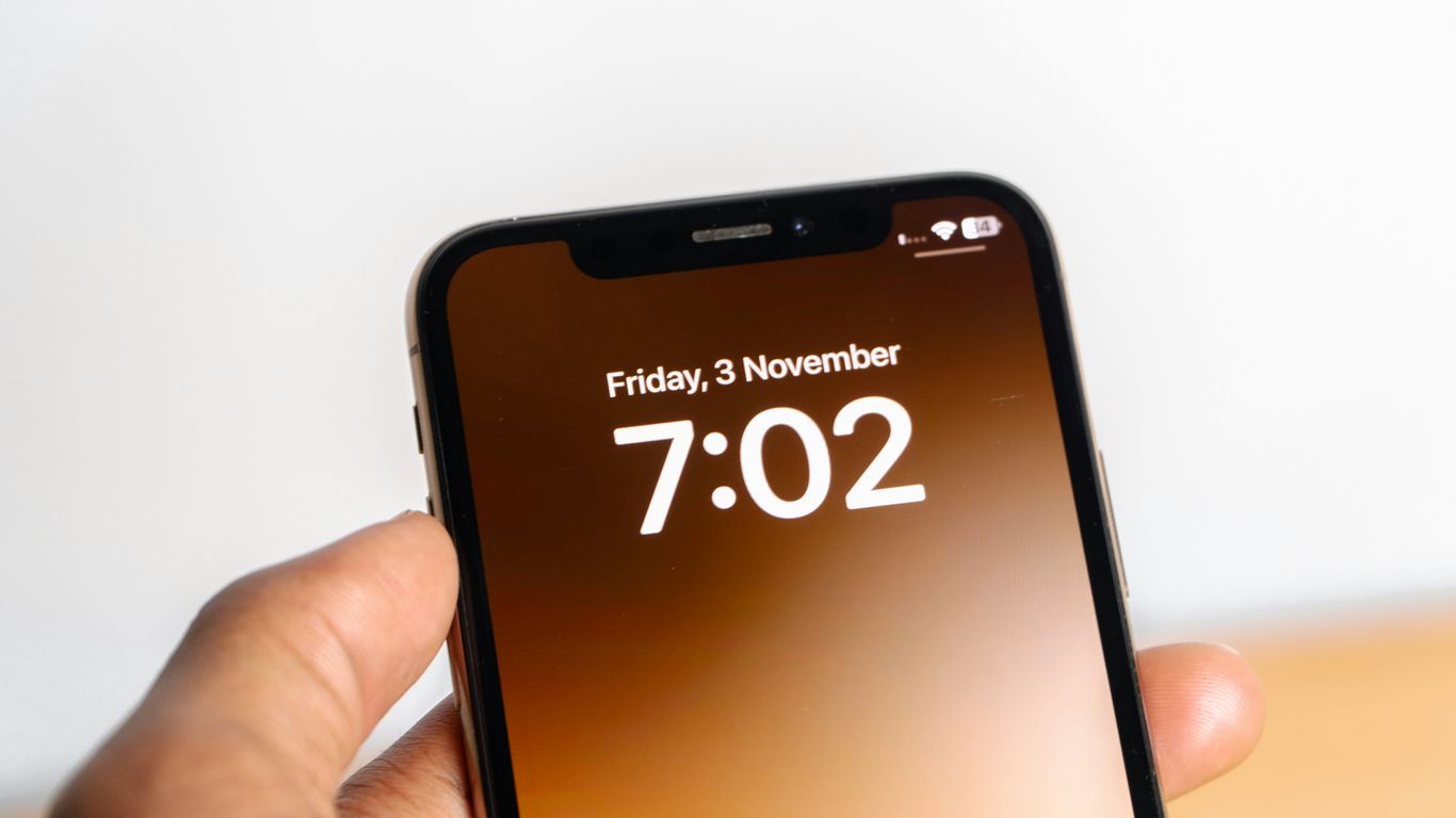 a person holding a cell phone with the time on it