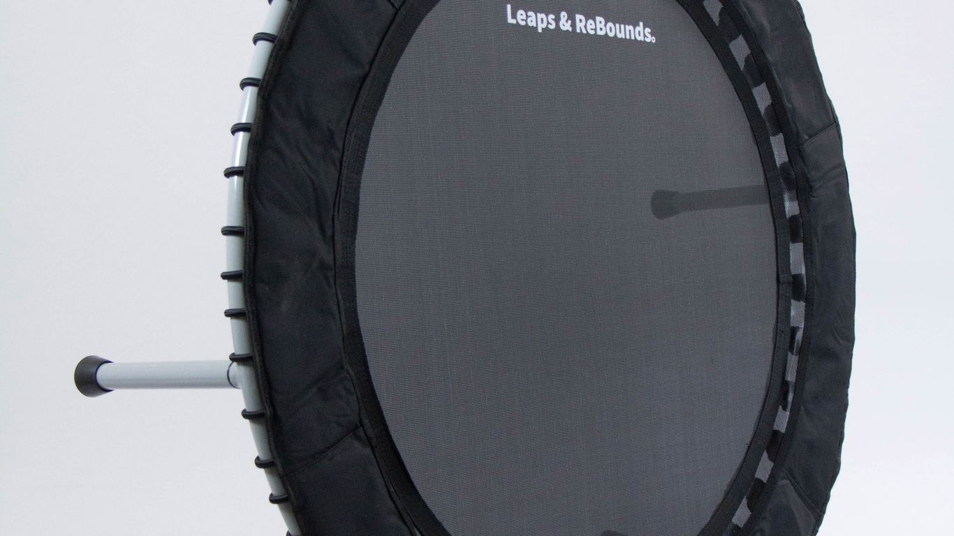 A small black exercise trampoline with three metal legs visible.