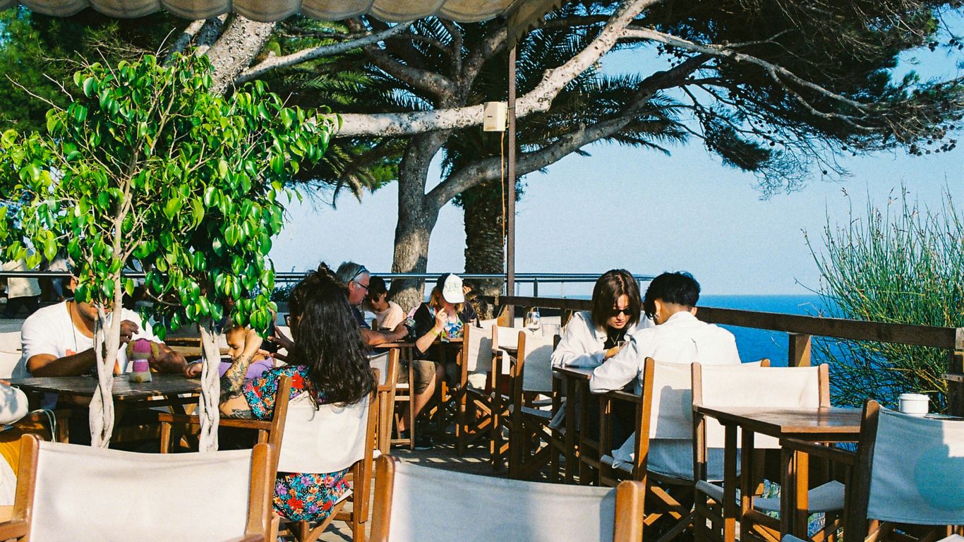 a group of people sitting at wooden tables