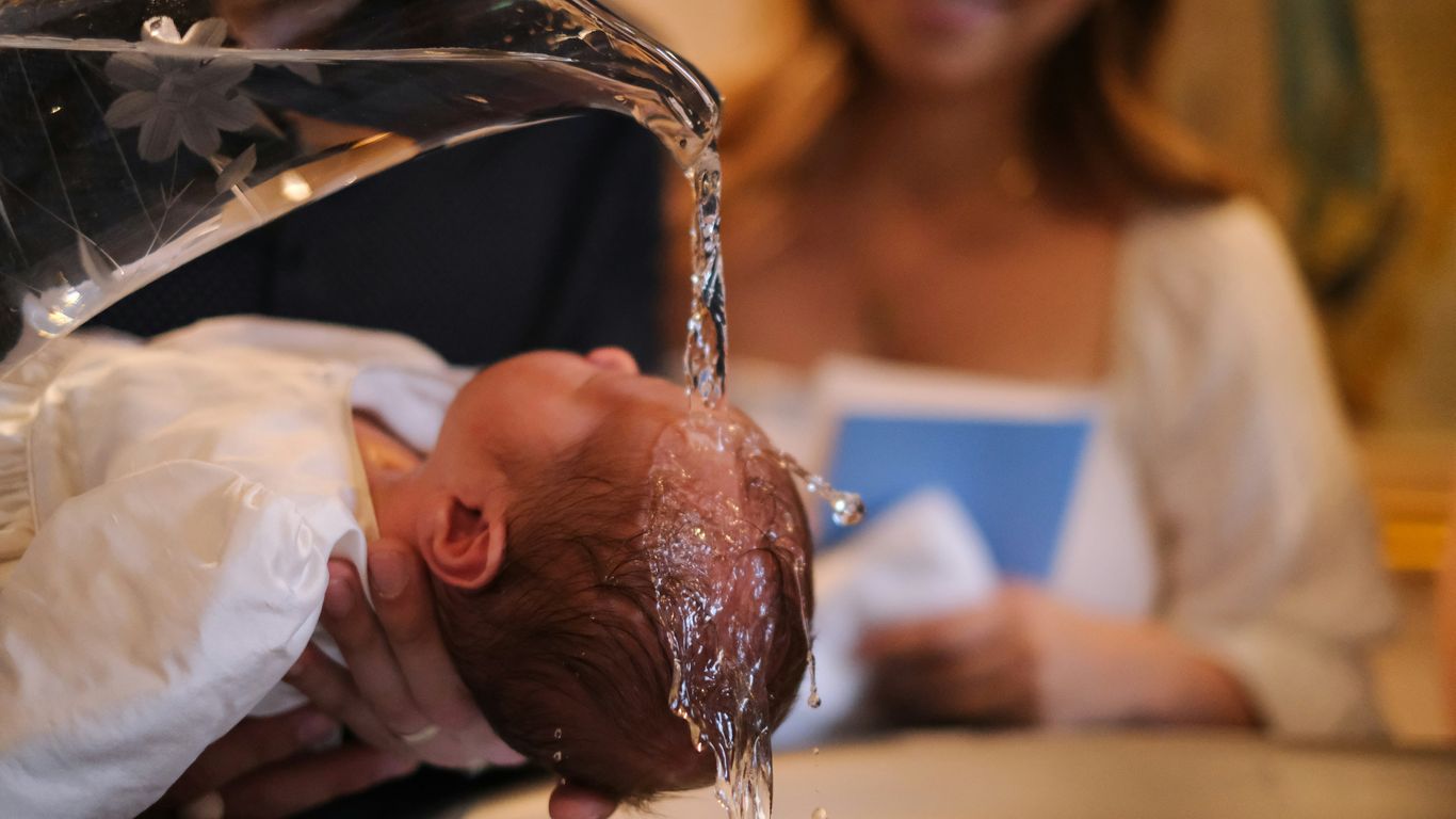 A baby being washed in a kitchen sink