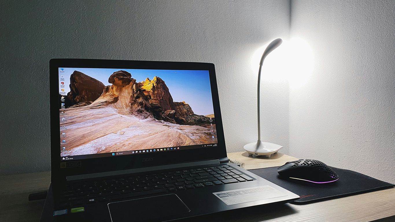 a laptop computer sitting on top of a wooden desk
