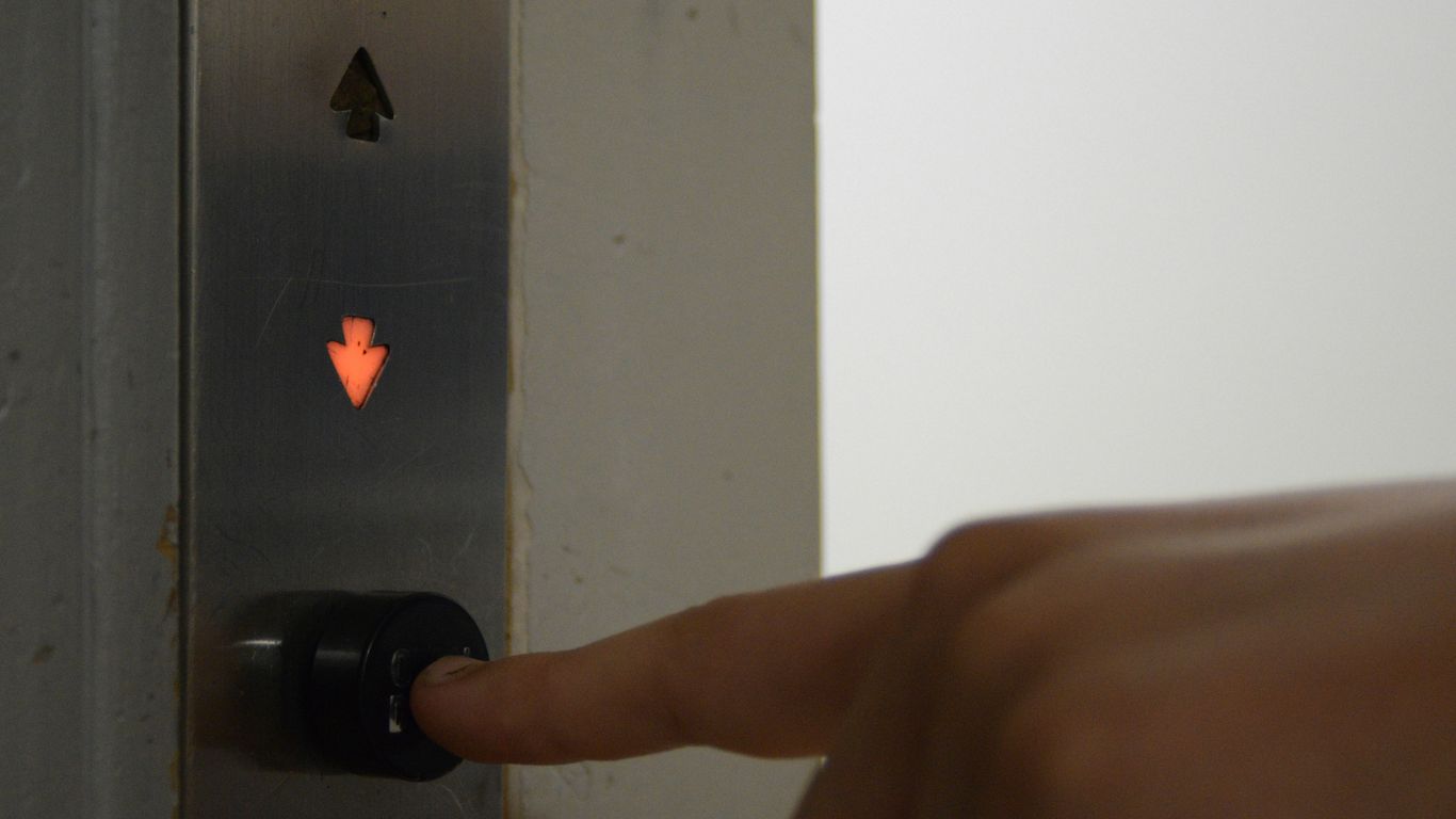 Someone is pressing the downward elevator button.