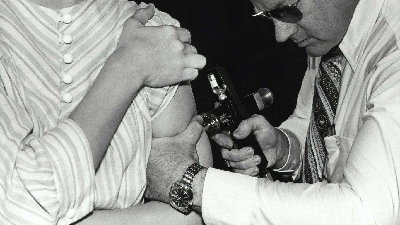 a black and white photo of a man holding a baby