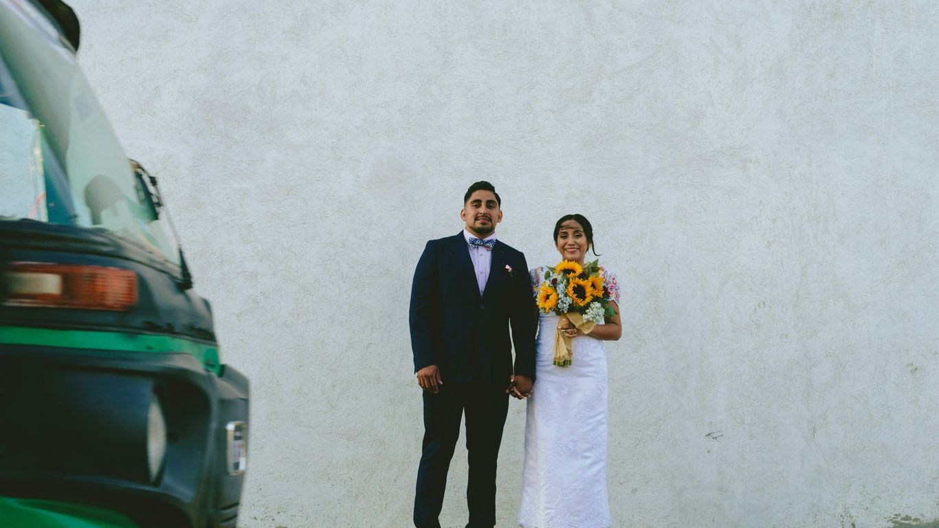 man in black suit standing beside woman in white wedding dress
