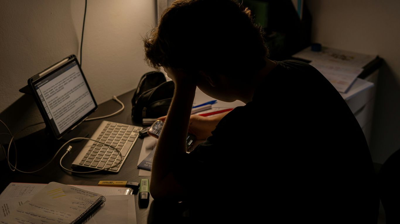 a person sitting in front of a laptop computer
