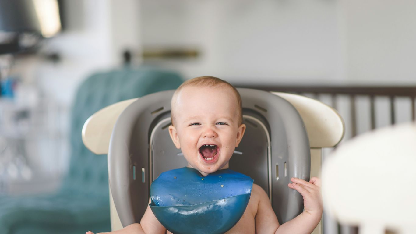 baby lying on white and blue bathtub