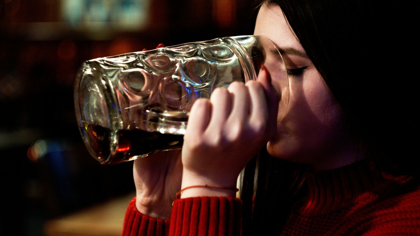 woman in red sweater drinking water