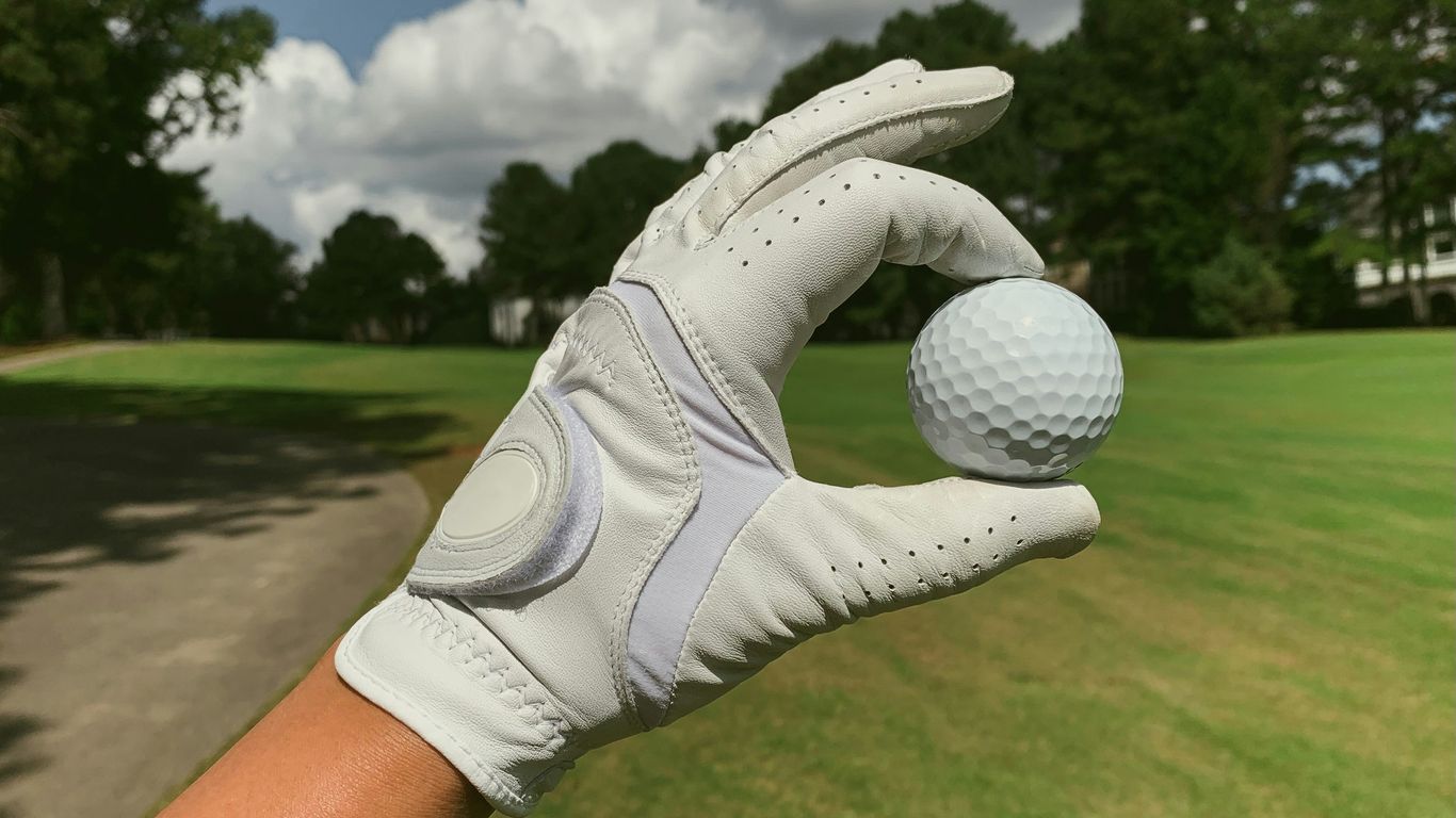 a person holding a golf ball in their hand