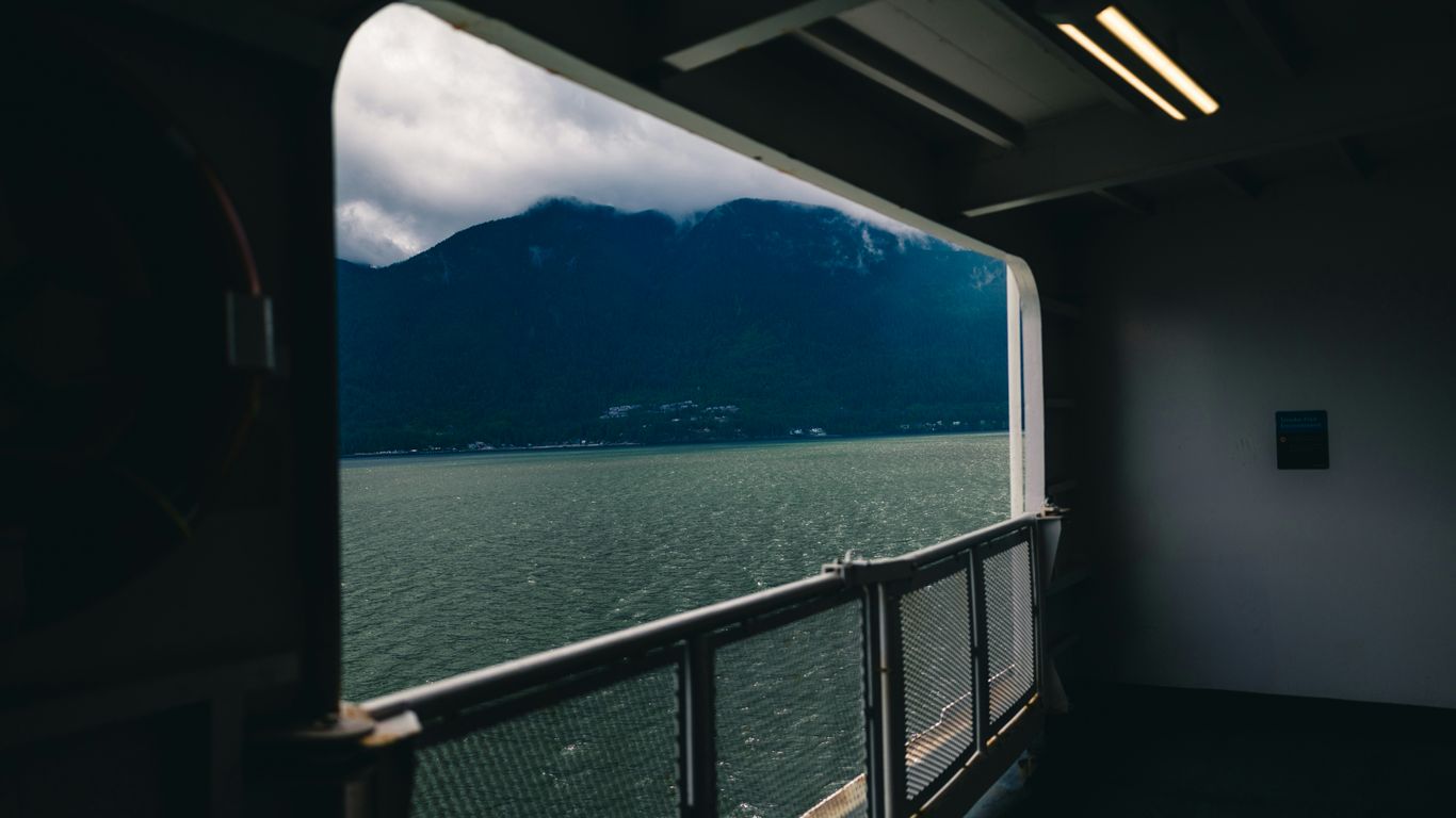 A window frames a view of mountain and water.