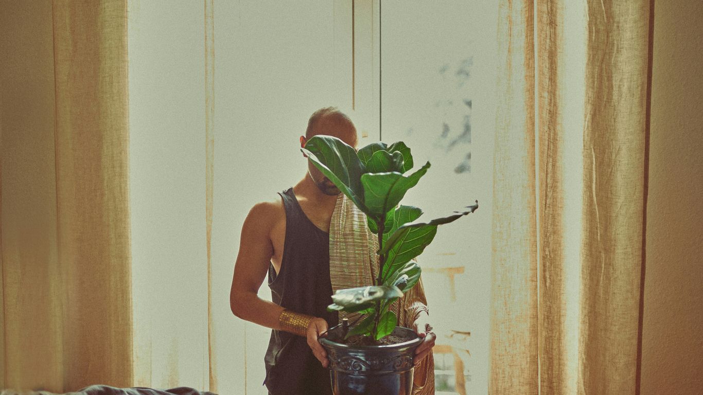 woman in black tank top holding green plant