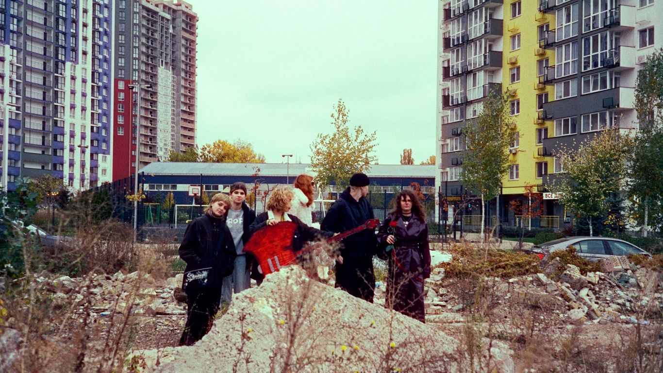 A group of people standing on top of a pile of dirt