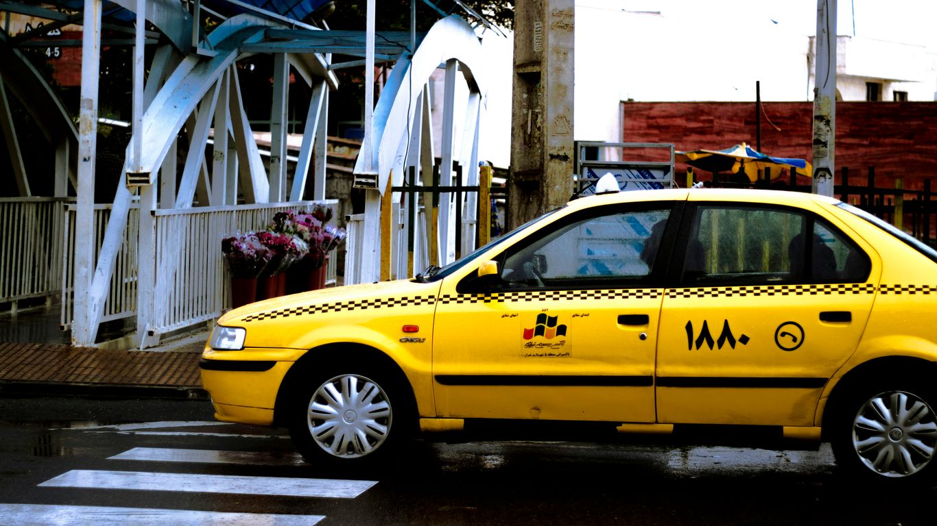 yellow car parked near white building during daytime