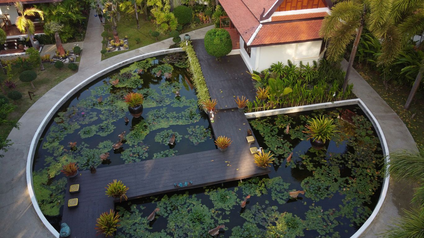 an aerial view of a house with a pond in front of it