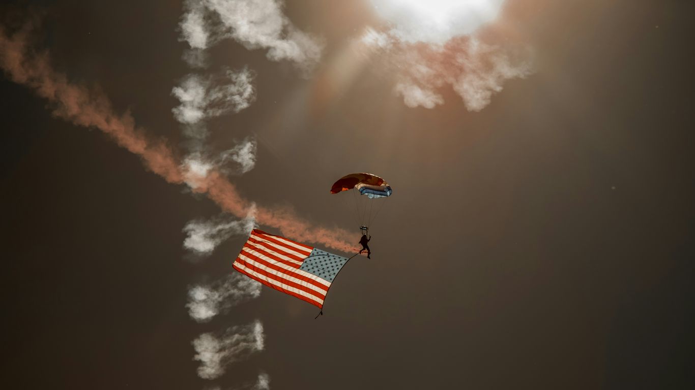 person in red parachute under cloudy sky during daytime