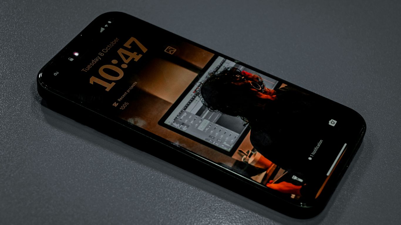 Smartphone displaying the time and a reflection