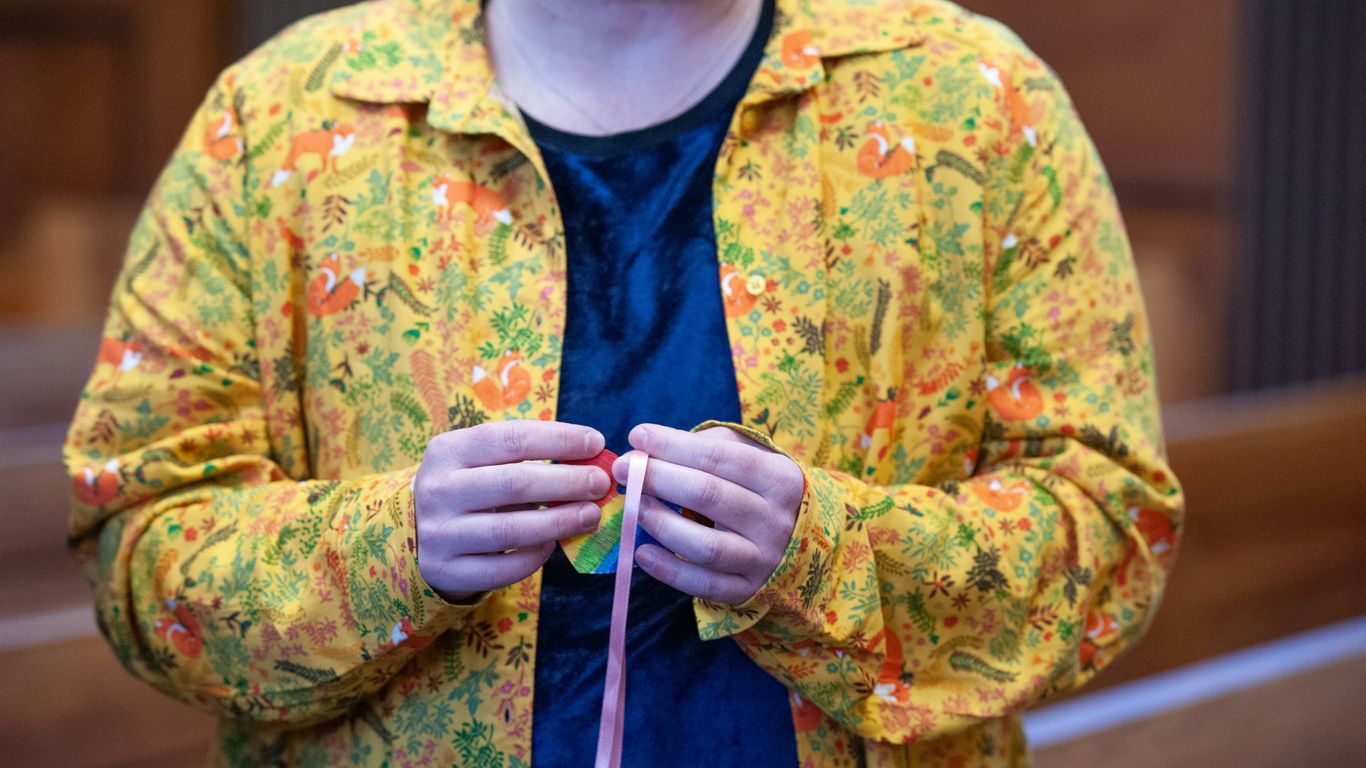 a woman in a yellow jacket is holding a string