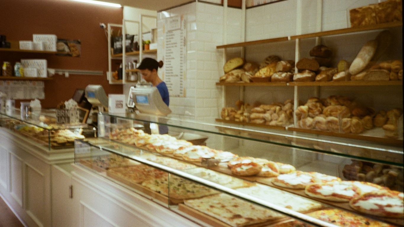 Bakery display with baked goods and staff member