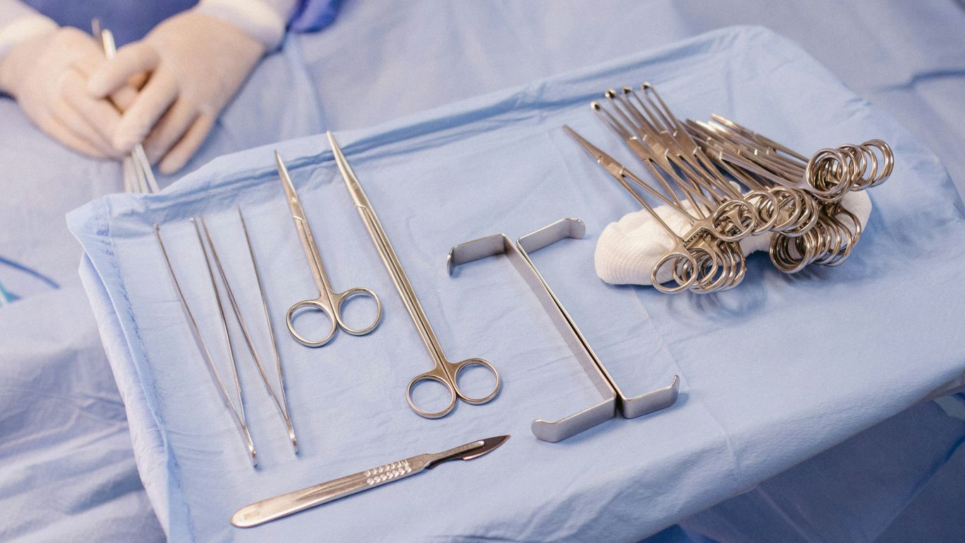A hospital bed with surgical equipment on top of it