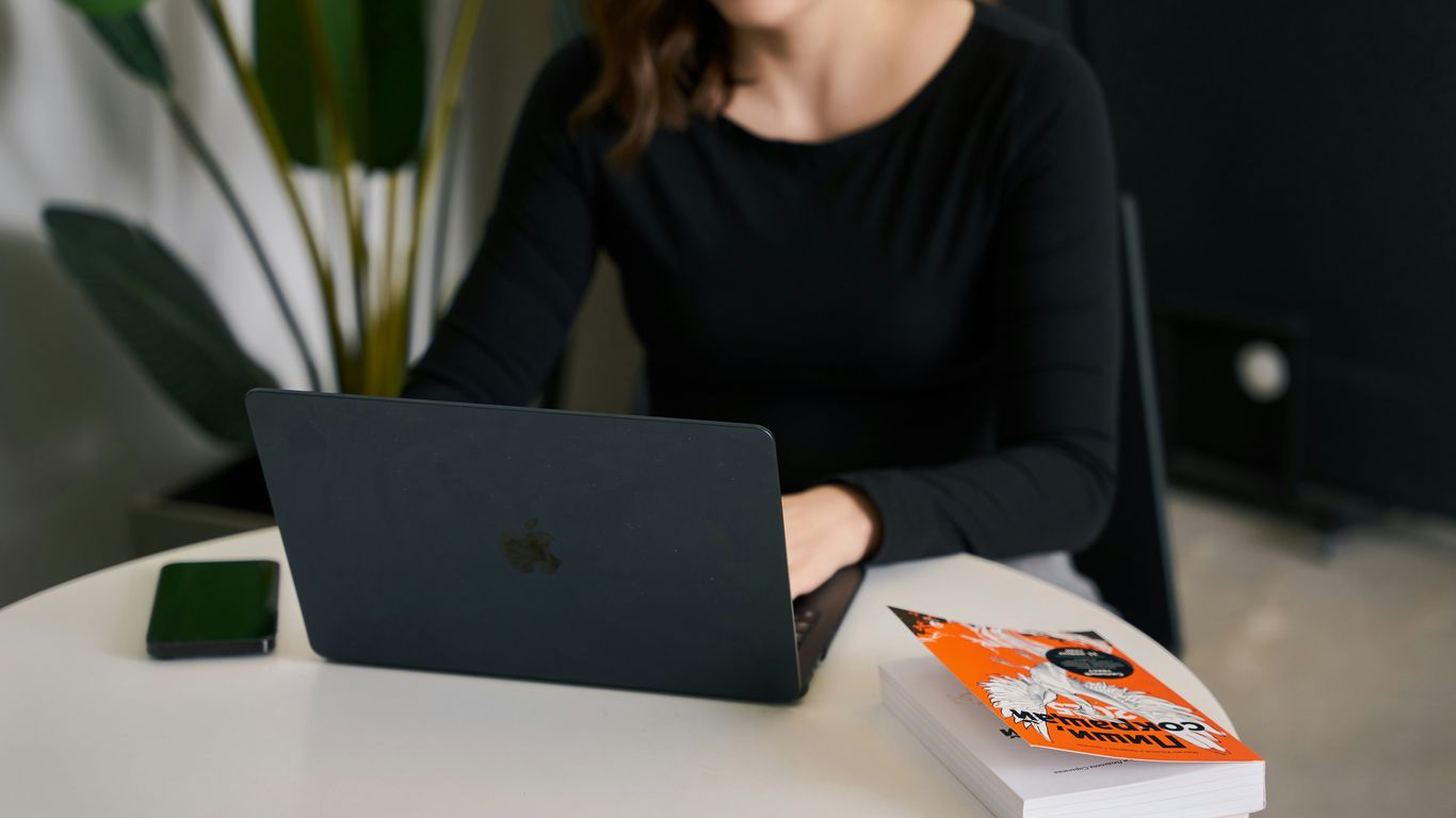 a woman sitting at a table with a laptop