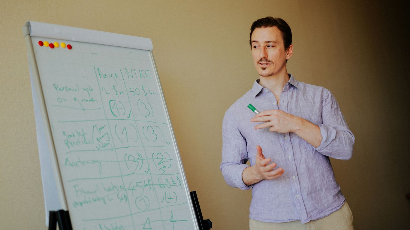 Man standing near a whiteboard with notes.